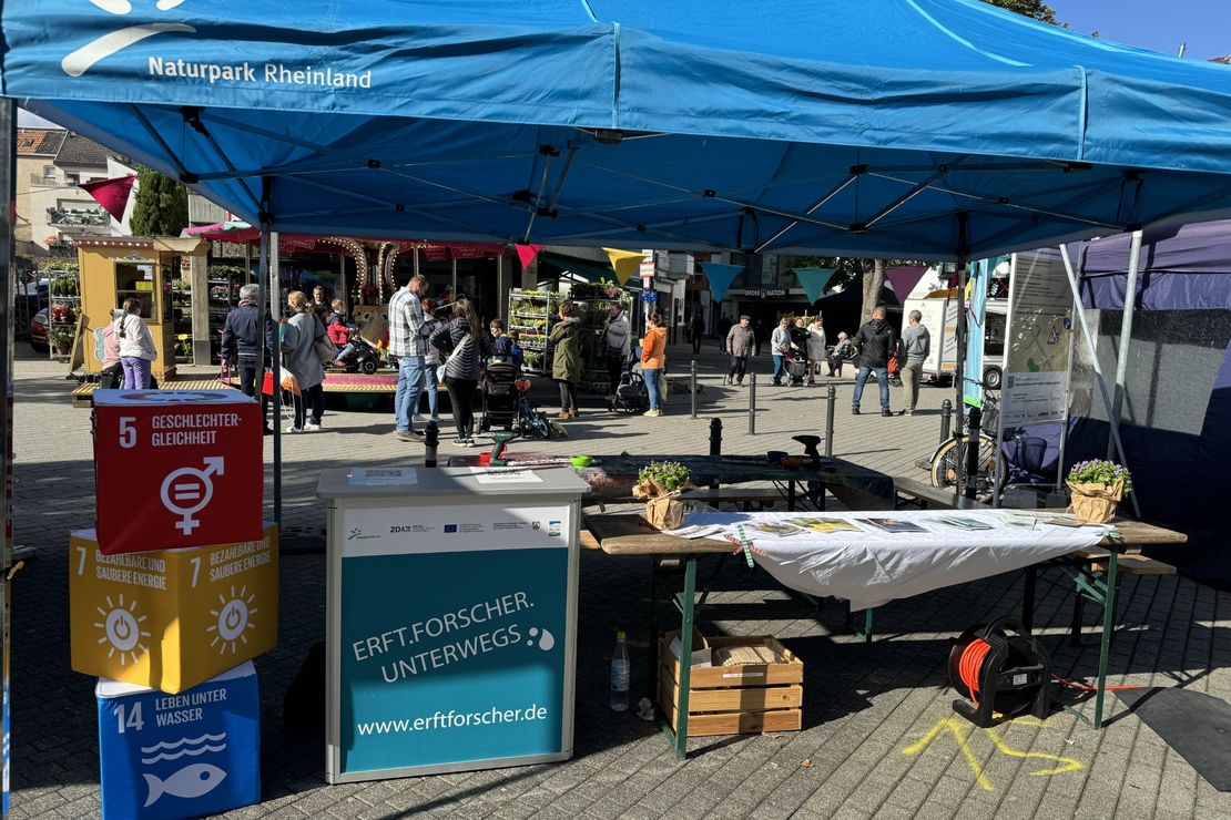 Informations- und Mitmachstand, im Vordergrund drei SDGs