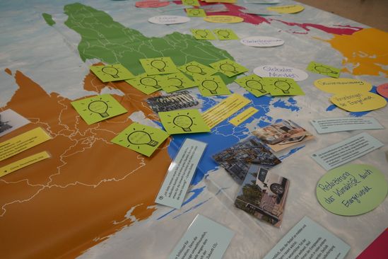 Weltkarte mit vielen Infozetteln auf verschiedenen Teilen der Erde.