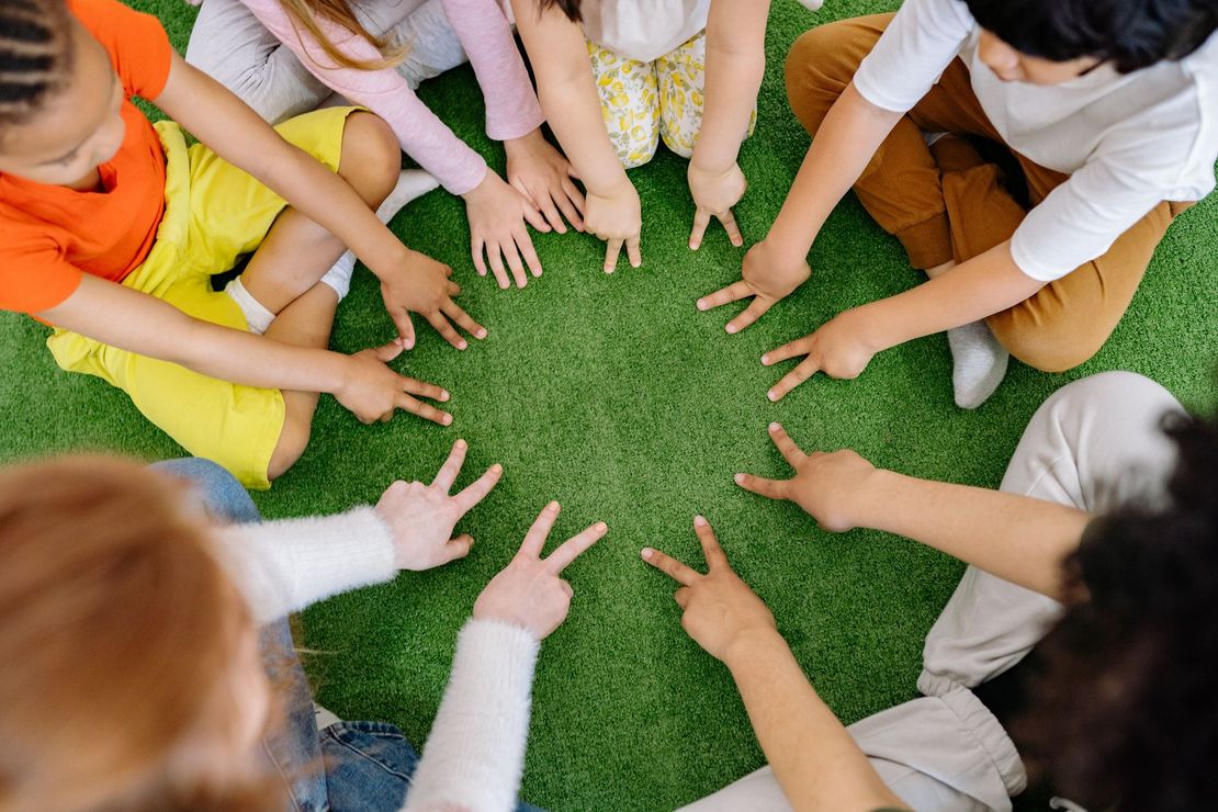 Kinder sitzen gemeinsam in einem Kreis.
