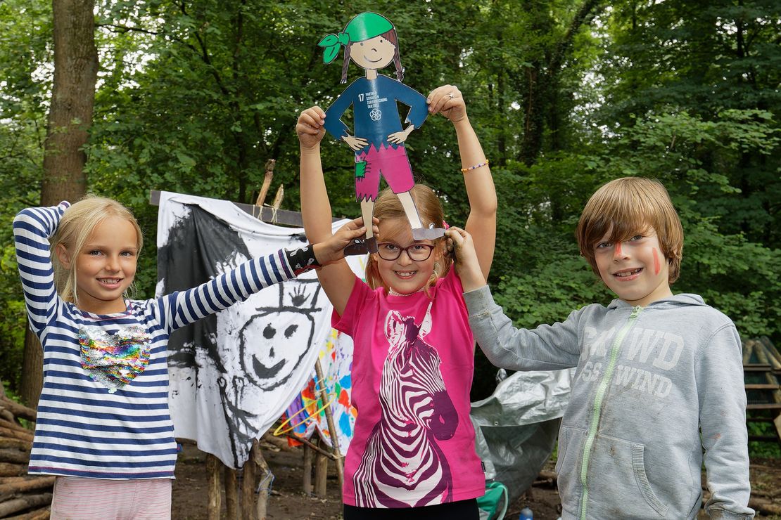 Drei Kinder zeigen einen gebastelten Piraten der Ferienwoche "Kapitän BeNe und die wilde 17". Den Rahmen der Ferienwoche bietet die Geschichte um Kapitän BeNE und seine Piraten-Crew, die Hals über Kopf das Schiff verlassen hat.