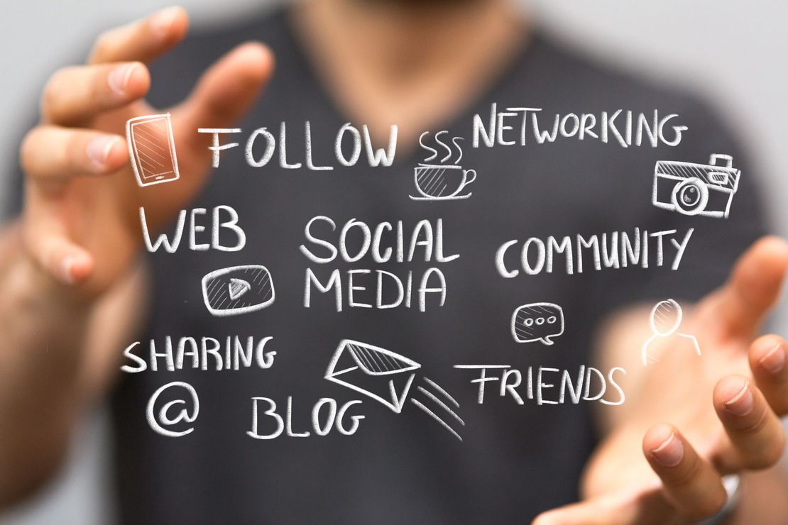 Bussword-Liste wie z.B. Web, Sozial Media, Community in Kreideschrift dargestellt vor einem verschwommen zu sehenden Menschen