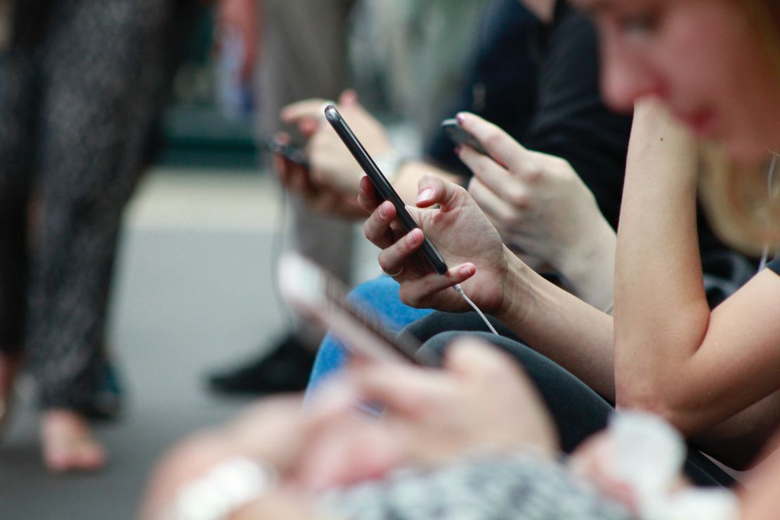 Auf dem Foto sieht man verschiedene Hände, die Smartphones halten