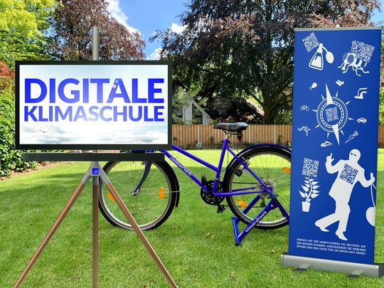 Ein Monitor, ein Fahrrad, das Strom erzeugt und ein Display mit illustrativen QR-Codes.