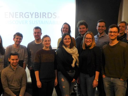Man sieht eine Gruppe von Personen vor dem Logo der Energybirds