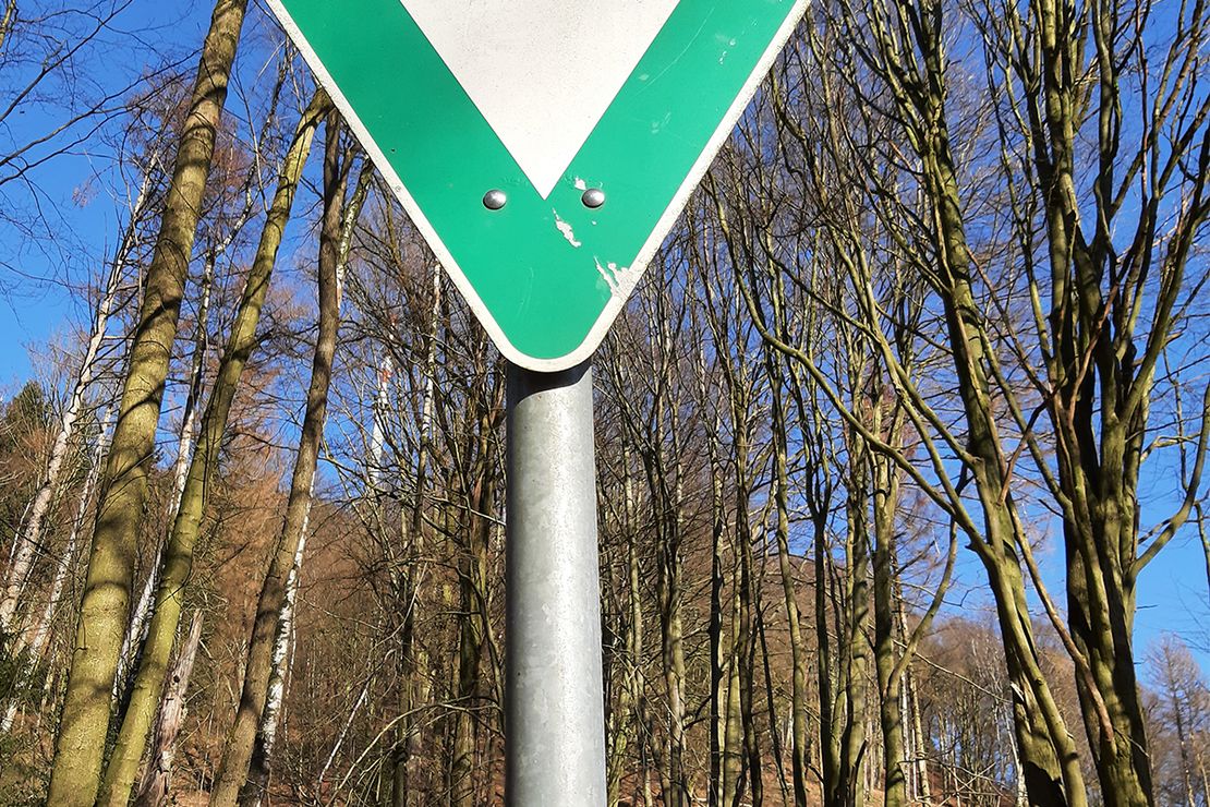 ein Naturschutzschild auf dessen Pfahl ein Sticker klebt auf welchem steht "love nature hate rascism