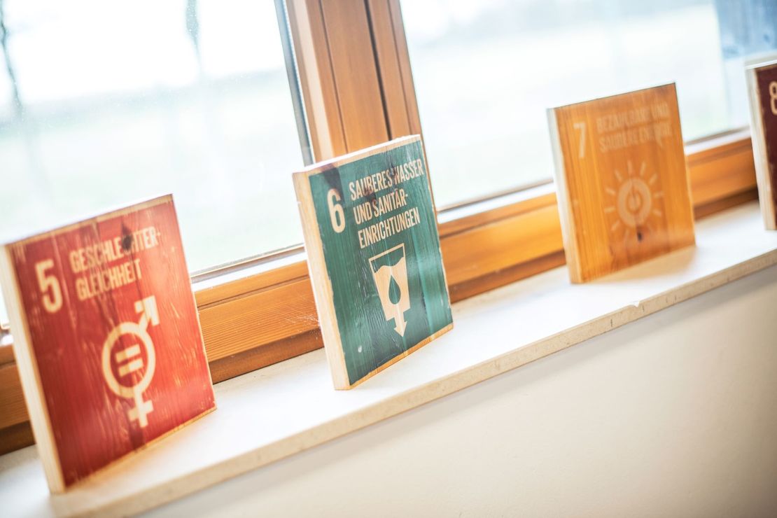 Holzaufsteller mit SDGs vor Fenster