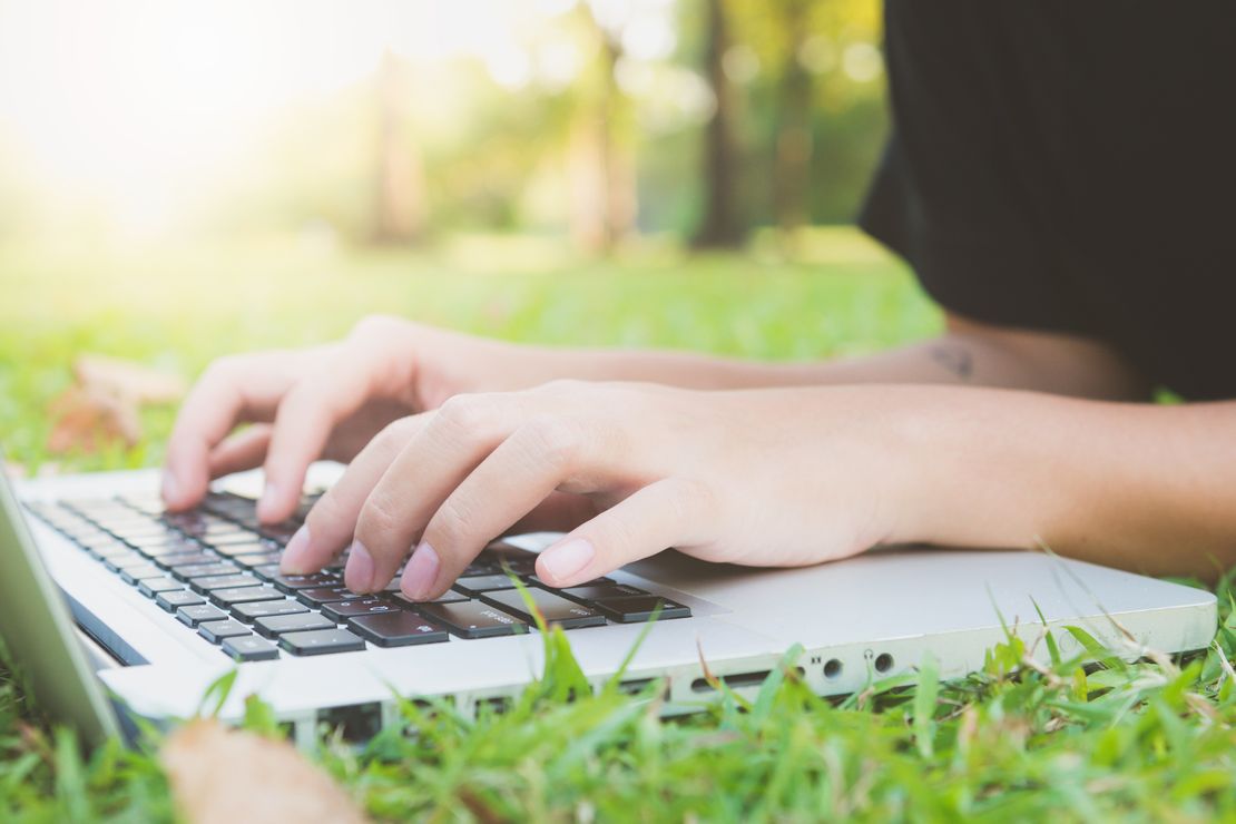 Laptop auf Wiese mit Kind