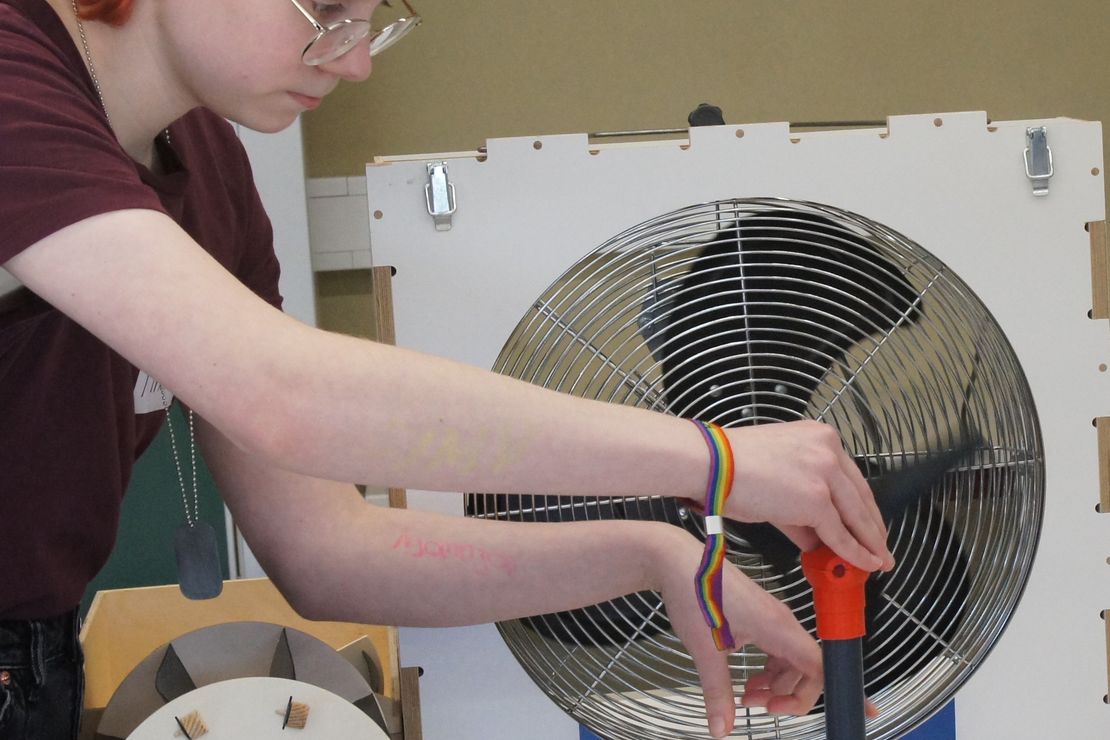 Schülerin experimentiert mit einem selbst zusammengebauten Windrad