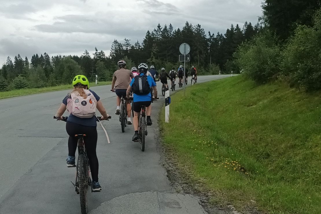 Schüler:innen mit Fahrradhelmen auf Mountainbikes.