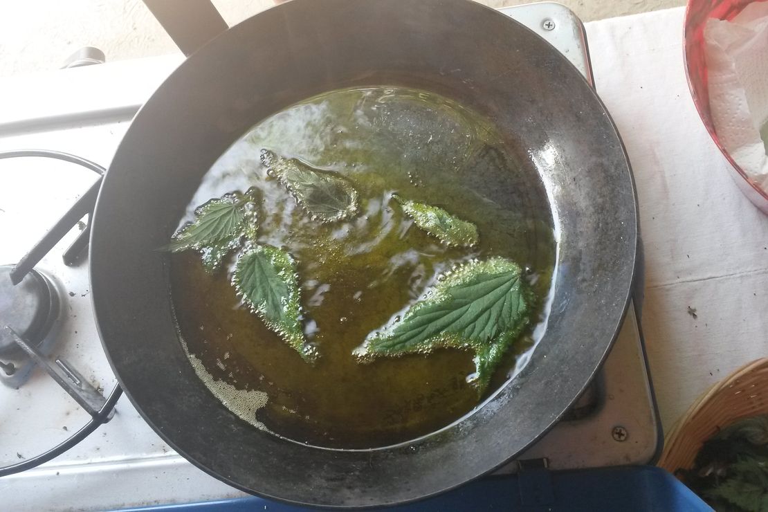 Wildkräuterfladen backen in einer Pfanne an einer Lagerfeuerstelle