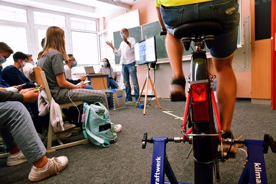 Ein Schüler erzeugt auf einem Fahrrad klimaneutralen Strom für das Klima-Quiz.