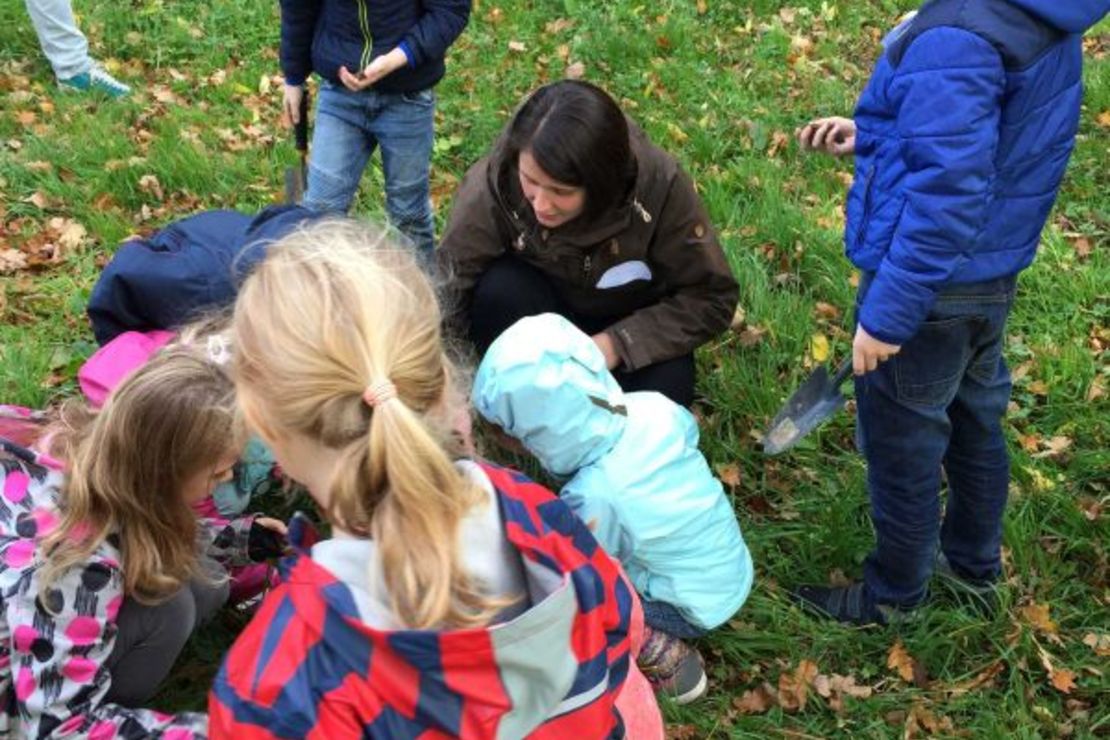Das Bild zeigt eine Kindergruppe, beim Suchen von Regenwürmern..