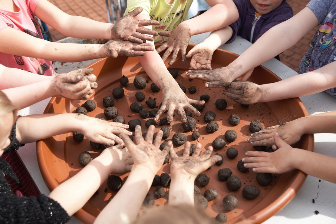 Eine Gruppe Kinder knetet Seedbombs.