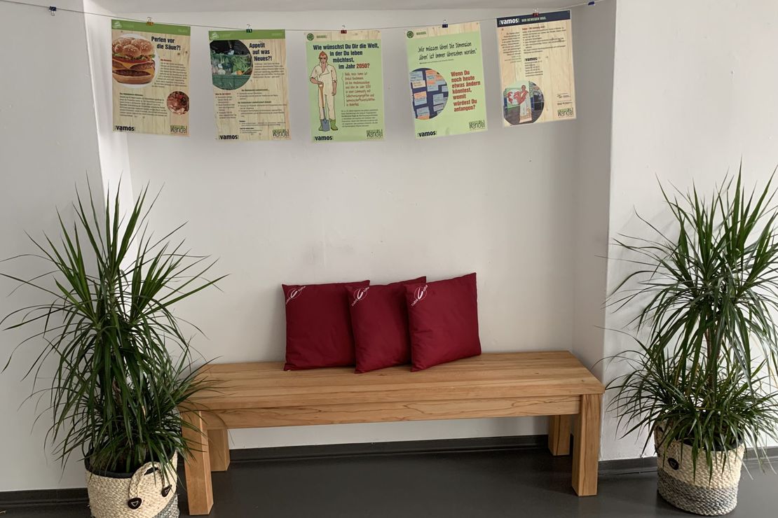 Ausstellungsplakate hängen über einer Bank