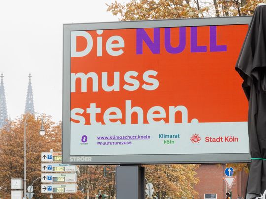 Werbedisplay im öffentlichen Raum mit der Aufschrift „Die NULL muss stehen.“ Darunter sind Hinweise auf die Klimaschutzkampagne der Stadt Köln, den Klimarat Köln und die Website klimaschutz.koeln zu s