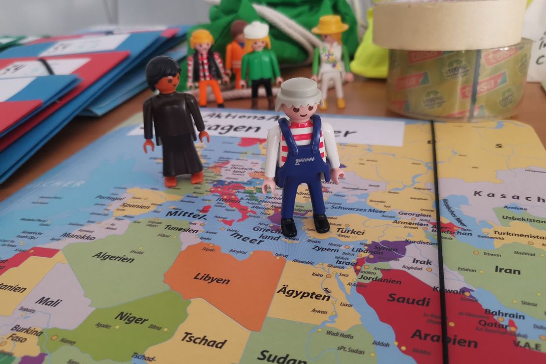 Spielfiguren vor einer Weltkarte