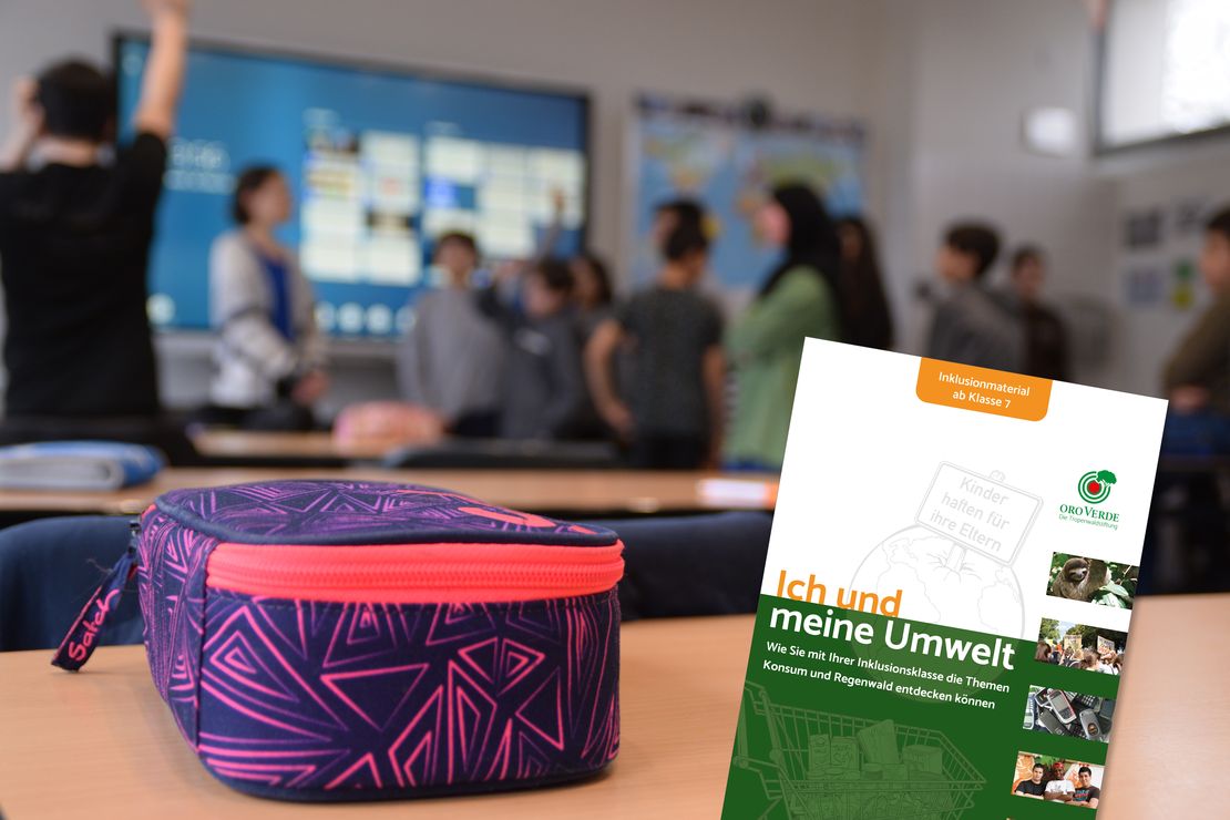 Titelbild extern Das Foto zeigt ein Klassenzimmer. Der Fokus liegt auf einem Schultisch, auf dem ein buntes Federmäppchen liegt. Im Hintergrund und unscharf sind Schülerinnen und Schüler zu erkennen.