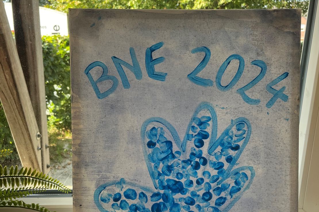 Blaue Fingerabdrücke bilden ein Herz mit der Aufschrift 4. BNE-Tag