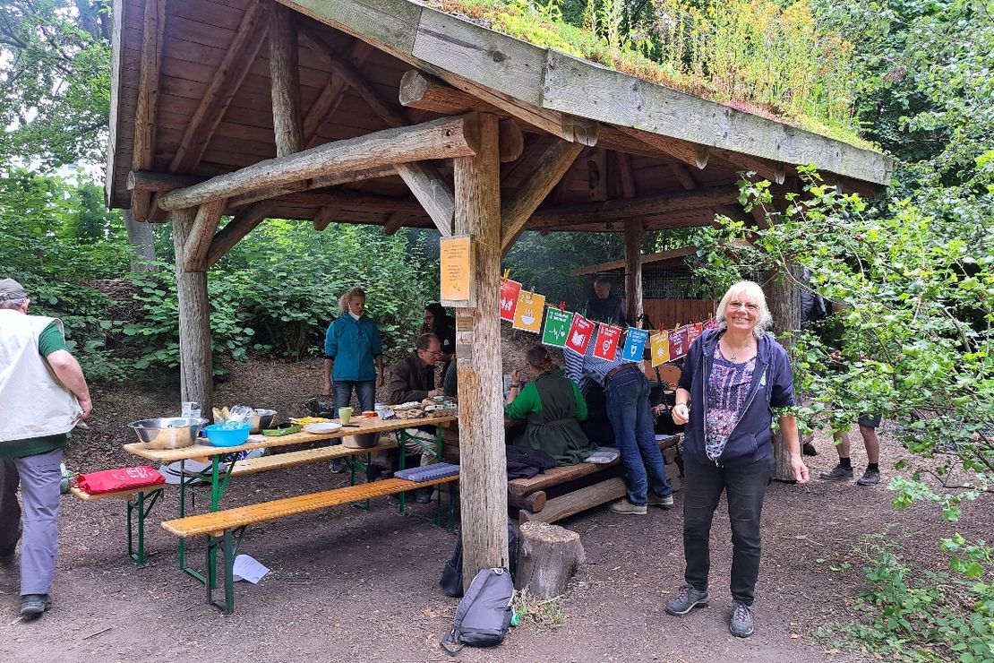 Menschen sitzen in einer Waldhütte um einen Tisch