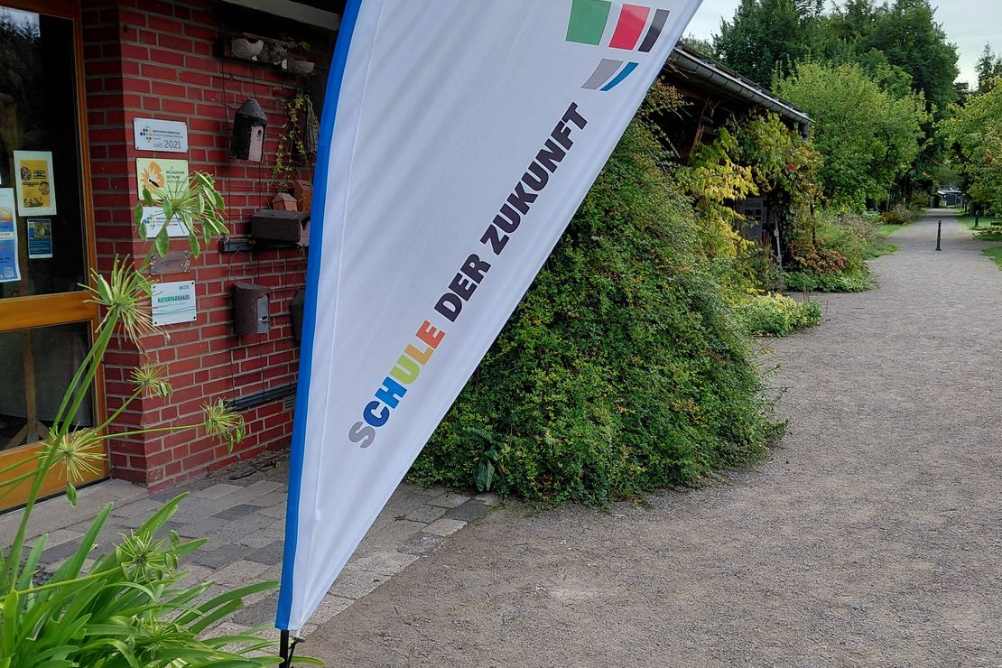 Eine Flagg des Landesprogramms Schule der Zukunft steht vor dem Gebäude des Biologischen Zentrums